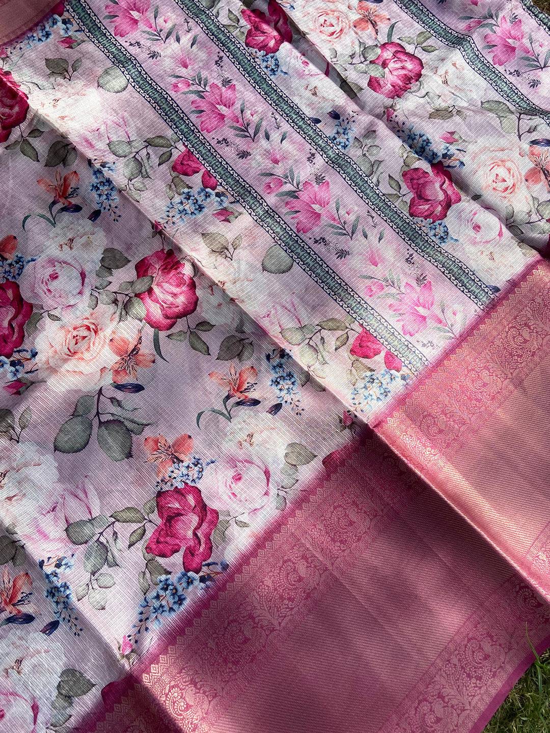 Close-up of pink saree with floral pattern and gold zari border