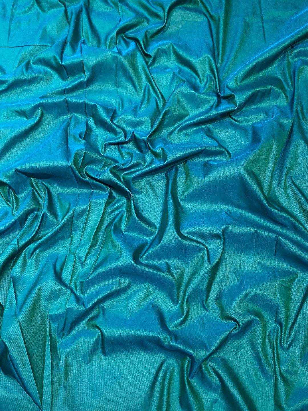 Close-up of green soft silk fabric with smooth texture