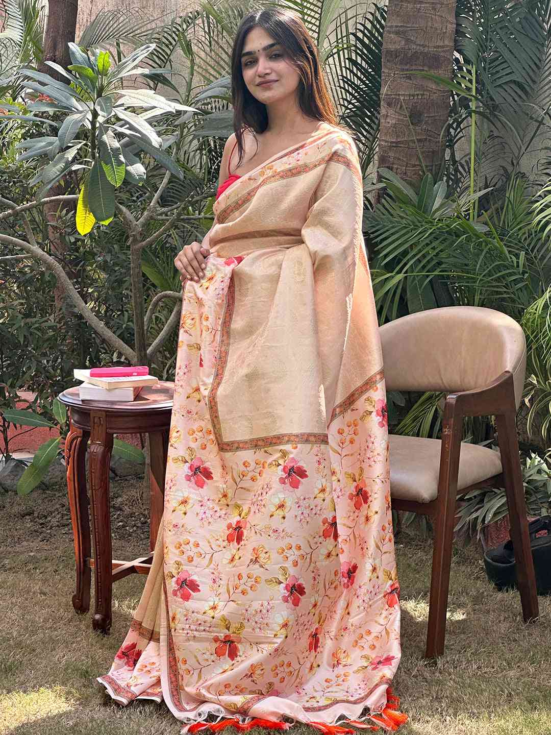 Model showcasing peach floral Kanjivaram saree in garden setting