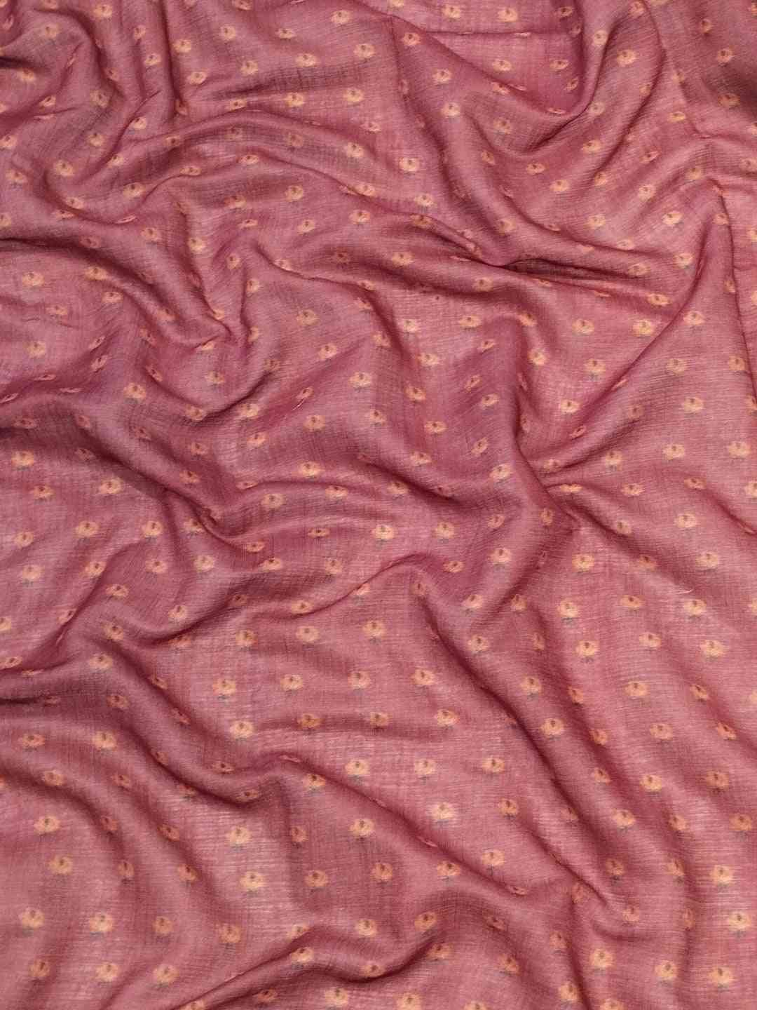 Close-up of pink fabric with subtle floral pattern