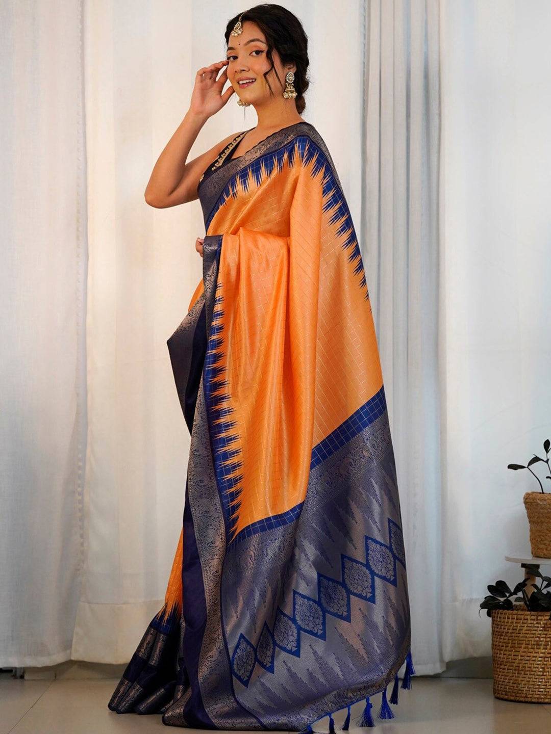 Side view of orange Banarasi saree with elegant blue patterns.
