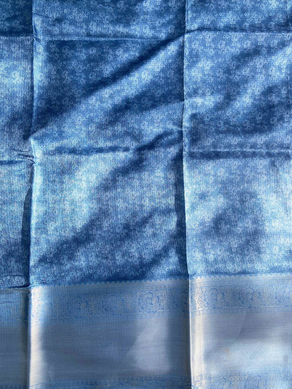 Blue saree fabric with subtle floral patterns