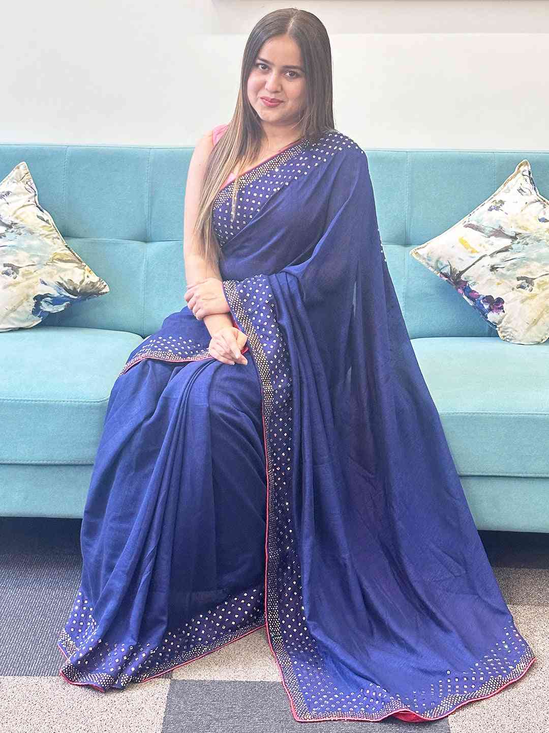 Navy silk saree with Swarovski stones, seated model.