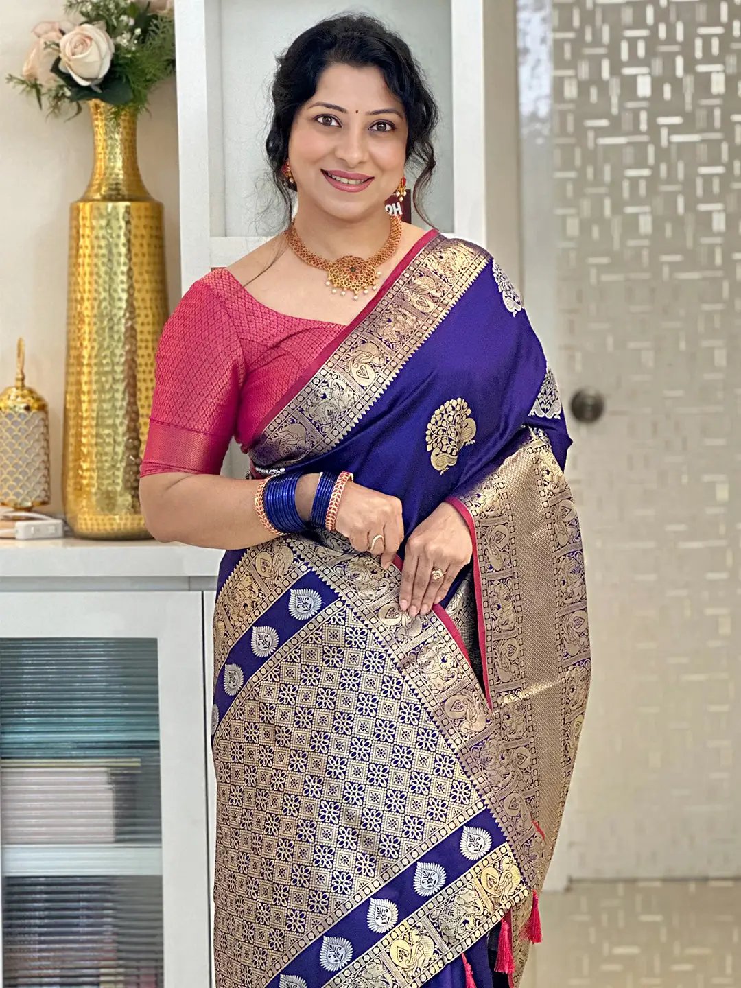 Model showcasing purple Banarasi saree with rich zari work.