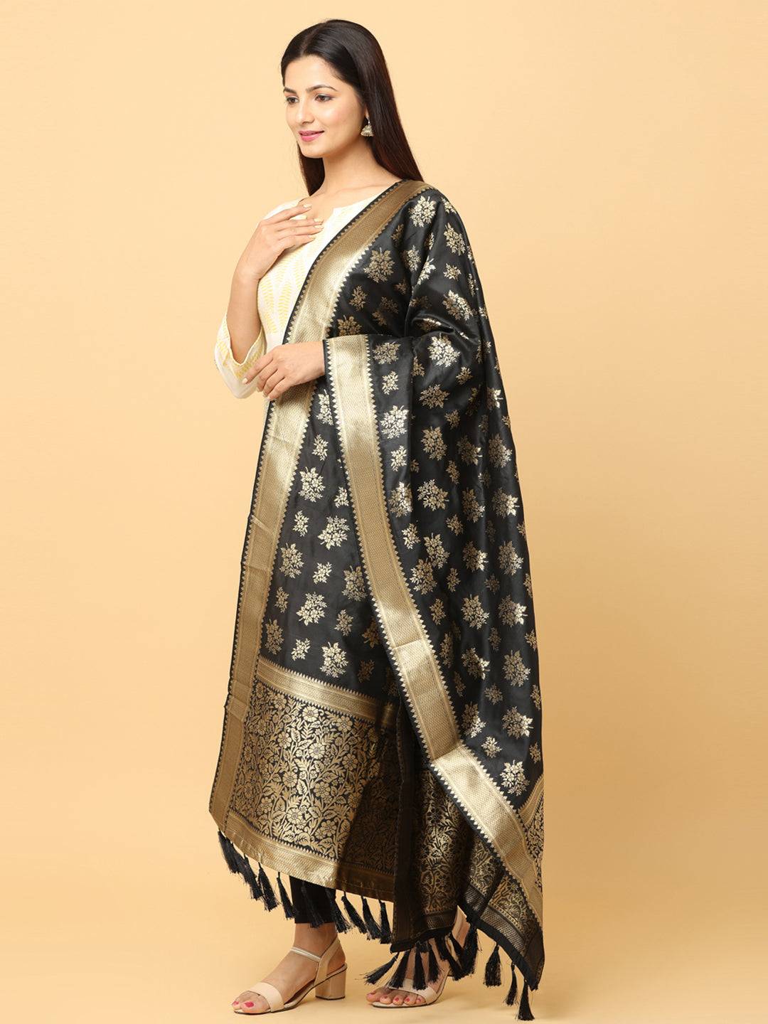 Side view of black silk blend dupatta with resham tassels.