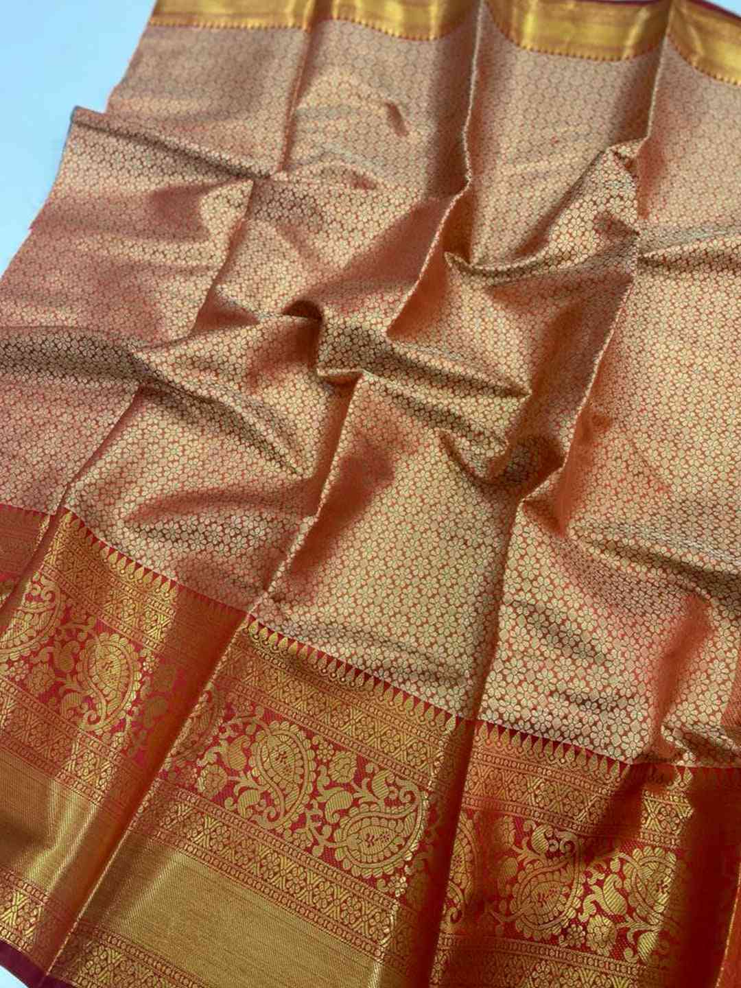 Close-up of gold zari Kanjivaaram silk saree fabric.