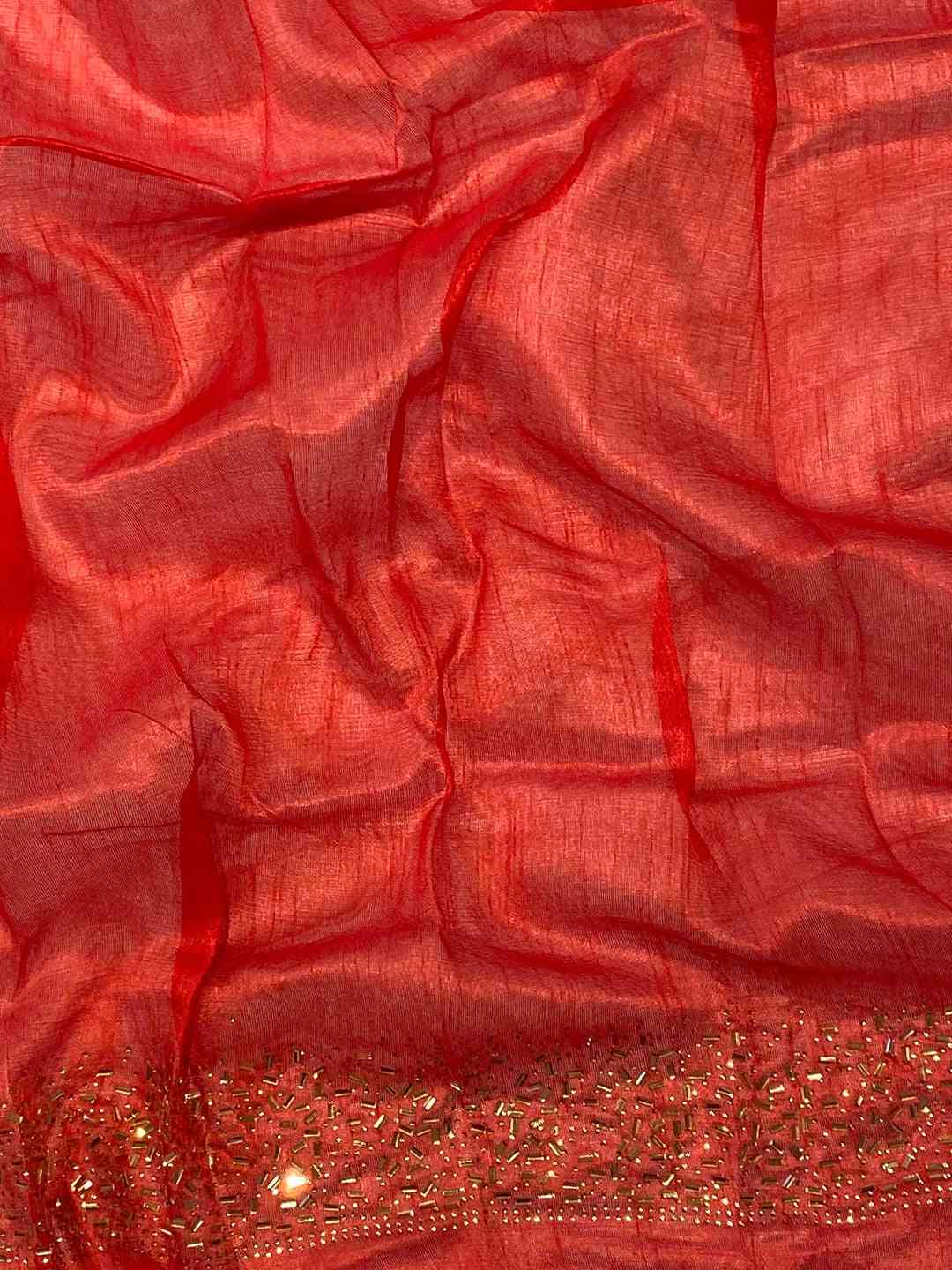 Close-up of red fabric with Swarovski stone embellishments
