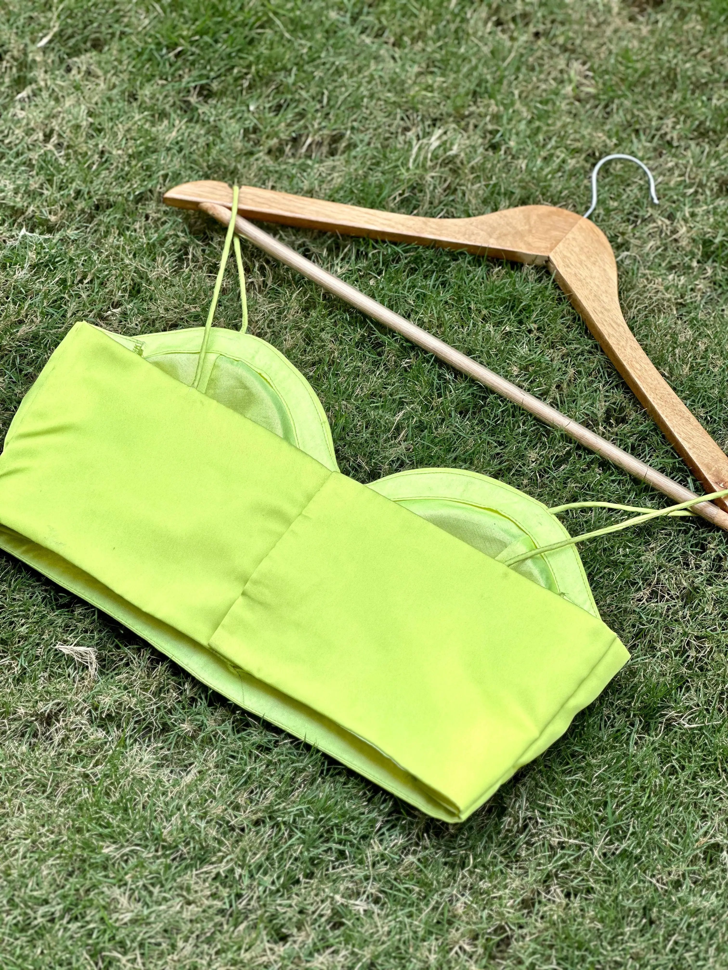 Back view of pista satin blouse on grass with hanger