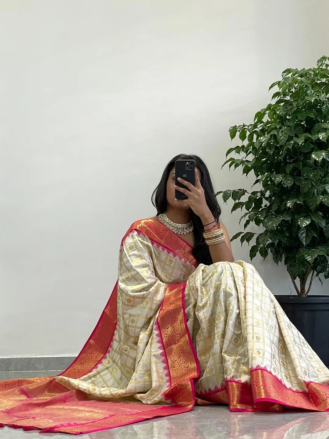 Model seated wearing Gadwal saree with pink temple border.