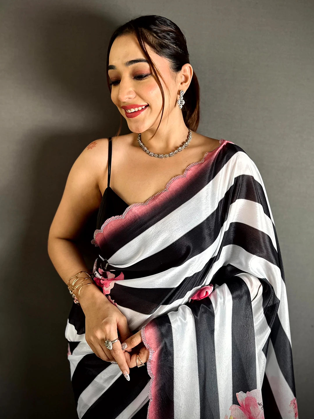 Black and white Soft Chinnon stripe print saree, close-up of the pink scalloped stone-edged border on the model's shoulder