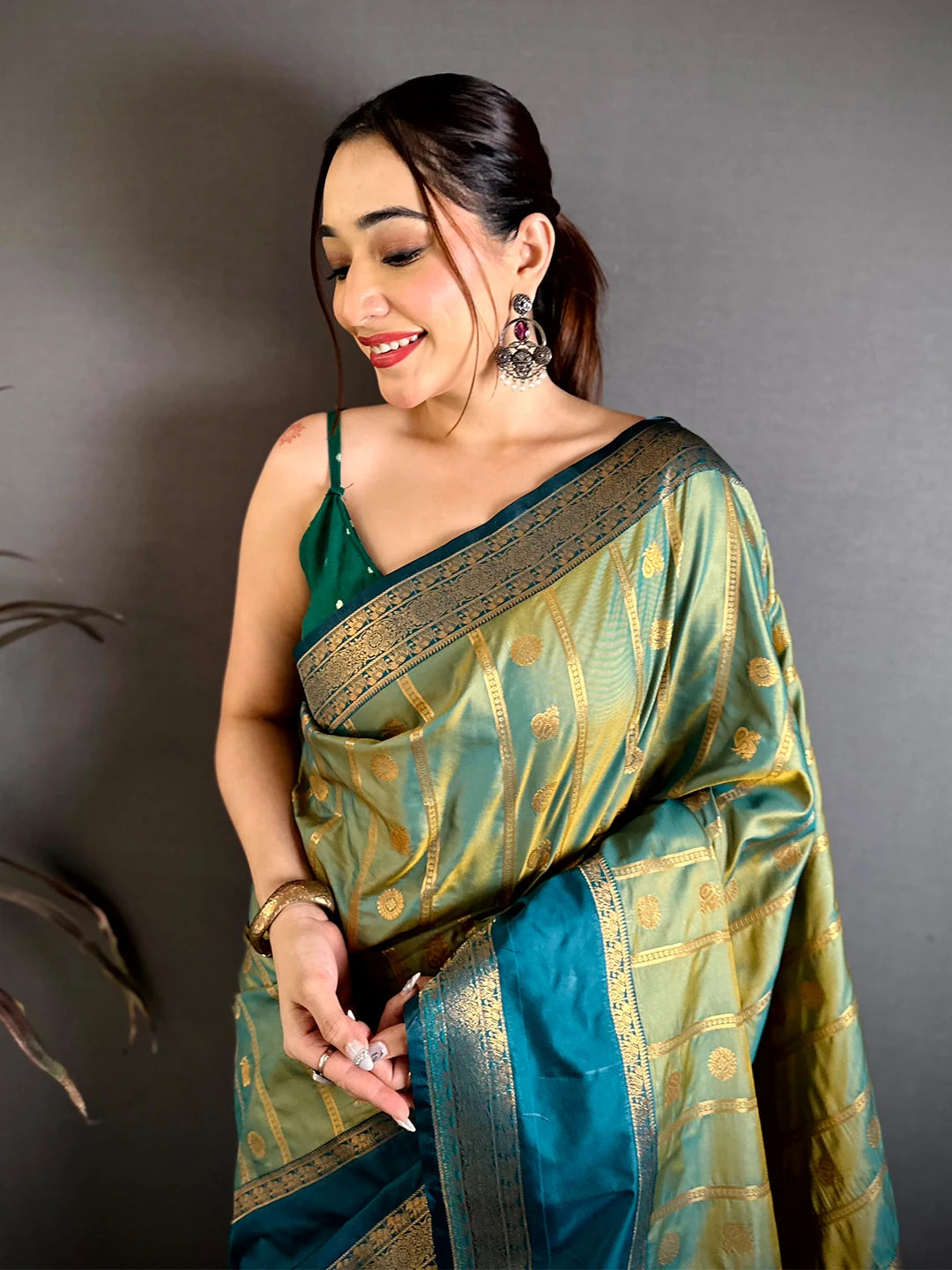 Pista green Banarasi silk zari butta saree, close-up front drape on model with teal border and green blouse