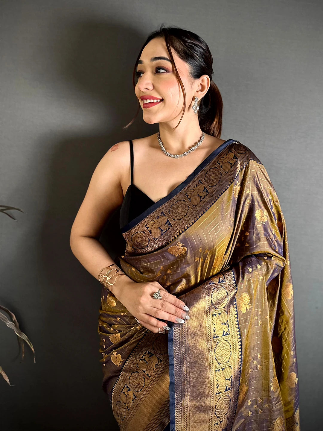 Deep bronze soft silk Kanchi-style saree, close-up of checked gold buti body and navy edged border on model
