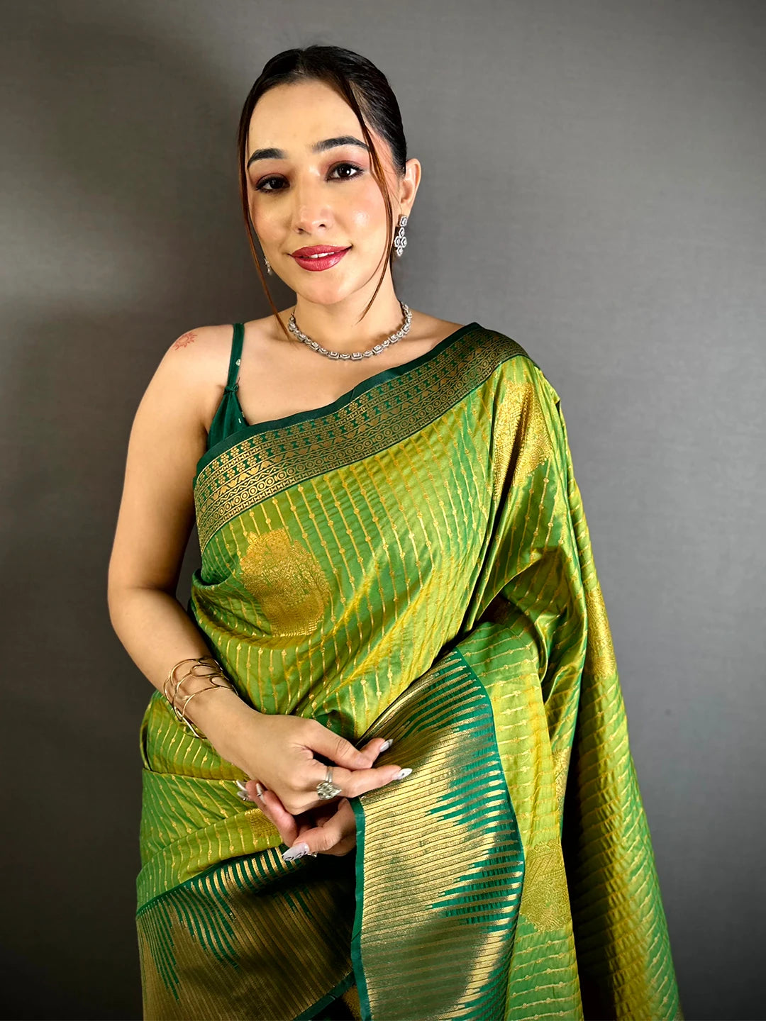 Green Soft Silk Zari Weave Saree, front drape on model showing gold buta motifs, stripe work and deep green border