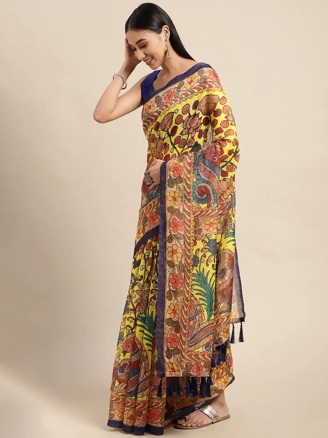 Yellow linen Kalamkari digital print saree, side view showing the draped pallu and navy tassels