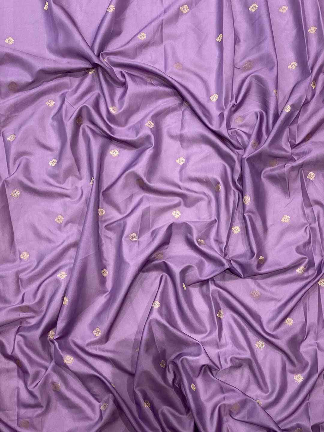 Close-up of violet silk fabric with gold motifs