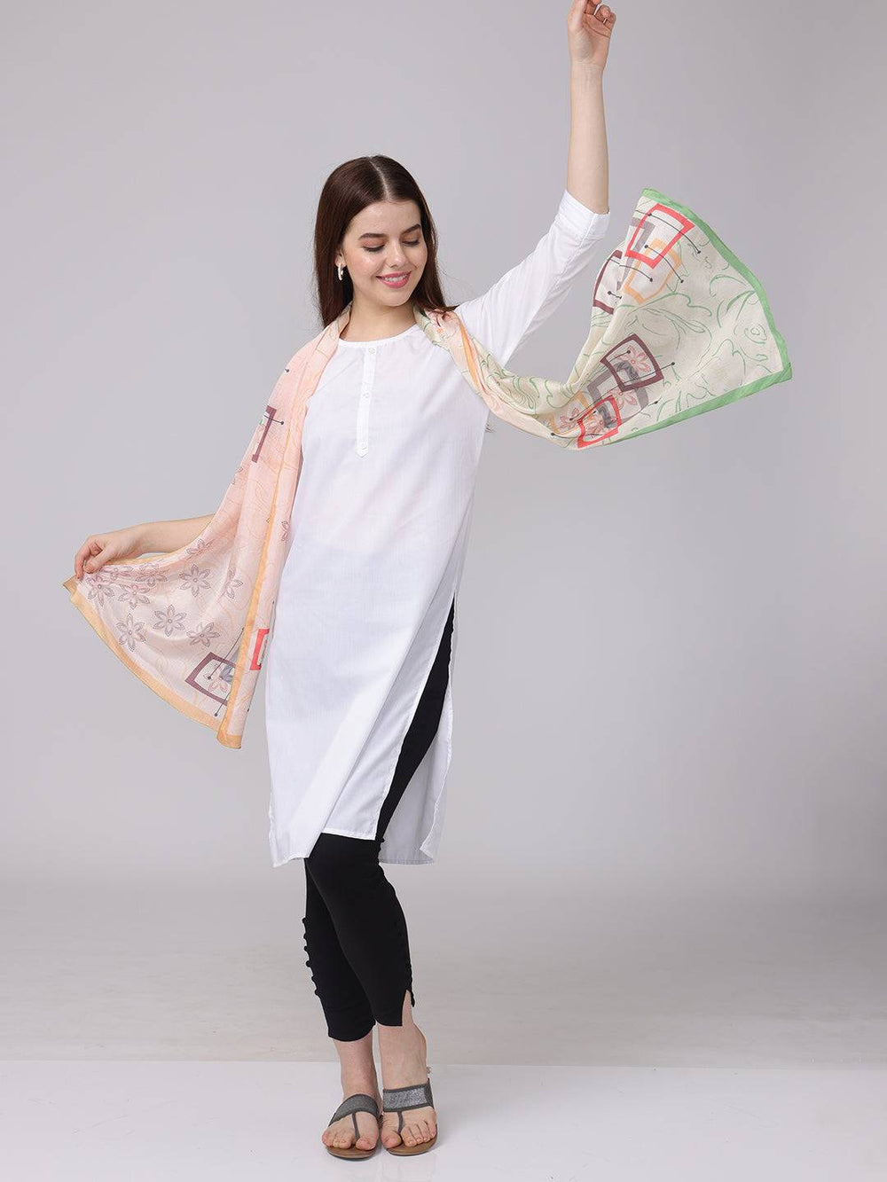 Floral geometric pastel scarf elegantly draped with arms extended.