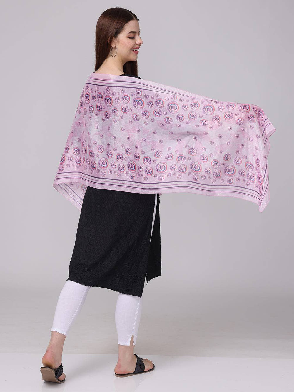 Side view of vibrant circular printed scarf in pink and purple.