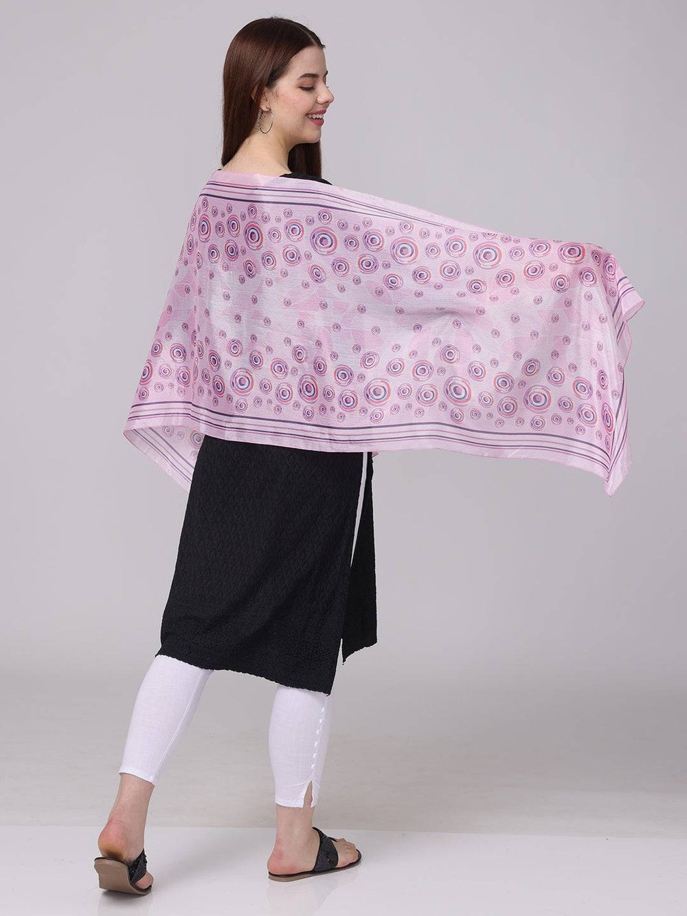 Side view of vibrant circular printed scarf in pink and purple.