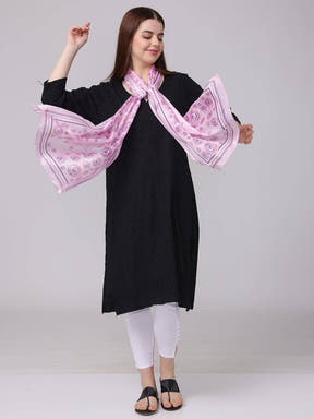 Model with vibrant circular printed scarf, arms extended.