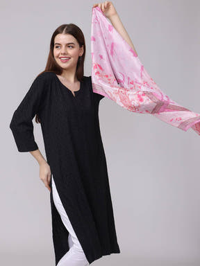 Woman holding pink paisley and floral scarf in hand