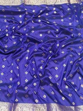 Close-up of purple Banarasi silk saree fabric with zari details.