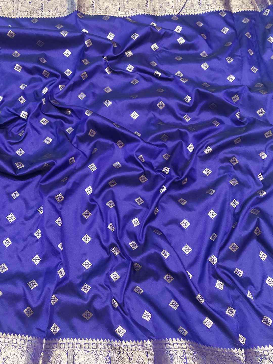 Close-up of purple Banarasi silk saree fabric with zari details.