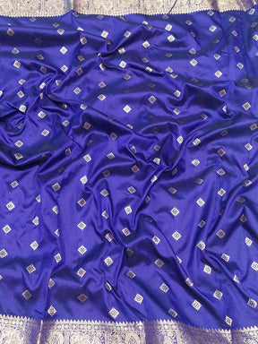 Close-up of purple Banarasi silk saree fabric with zari details.