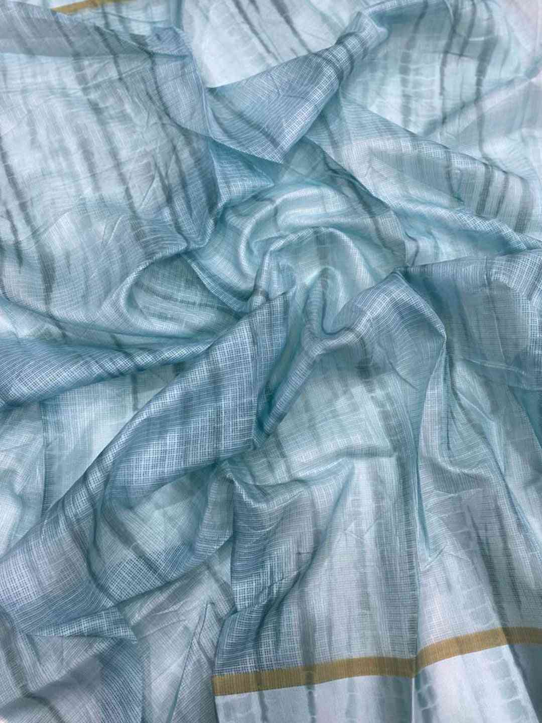 Close-up of light blue satin Kota Doria fabric with patterns