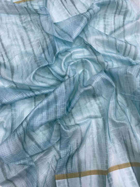 Close-up of light blue satin Kota Doria fabric with patterns
