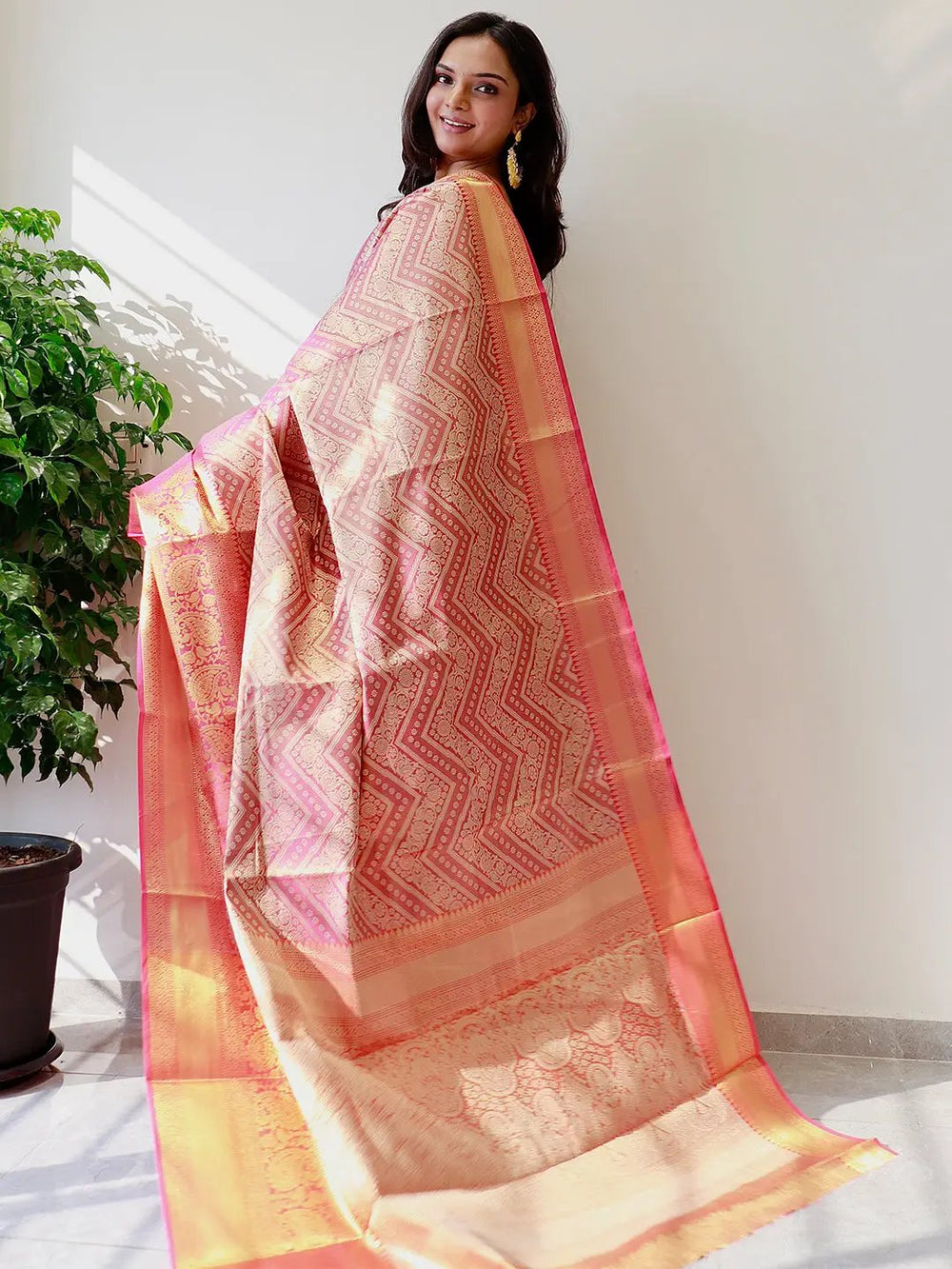 Back view of gold zari Kanjivaaram pattu silk saree with intricate patterns.