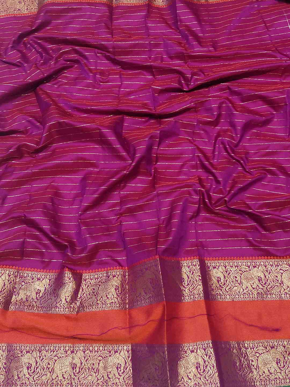 Close-up of wine Banarasi silk saree with gold zari border