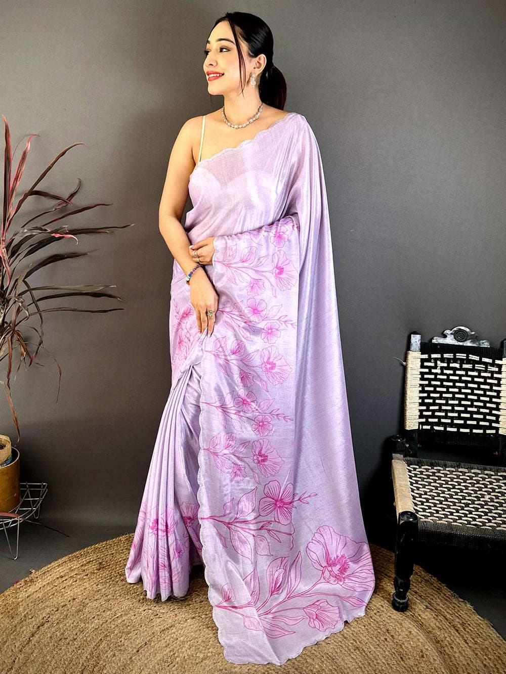 Model wearing lavender floral cutwork saree with jewelry and stylish pose
