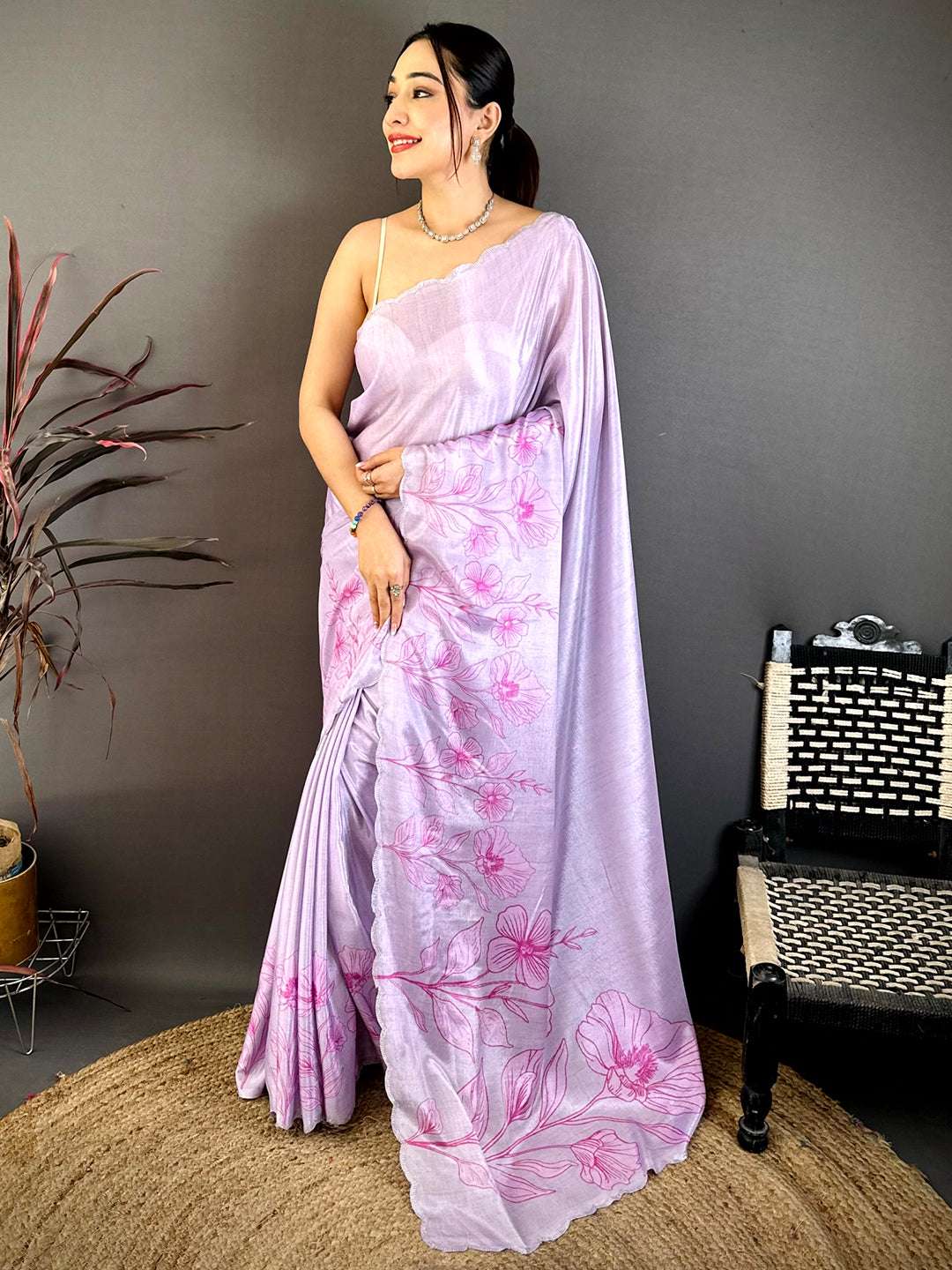 Model wearing lavender floral cutwork saree with jewelry and stylish pose