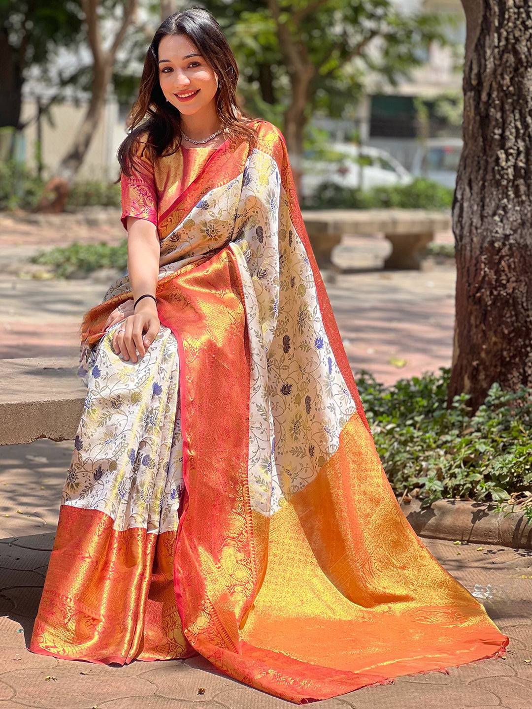 Woman sitting in red and gold Banarasi silk saree