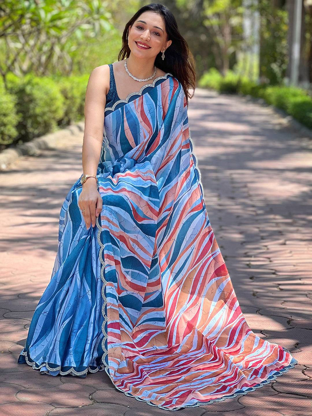 Seated woman in blue batik and polka dots print saree