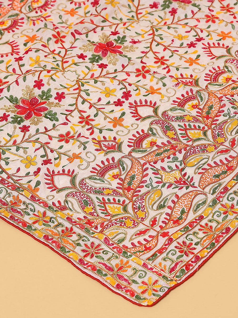 Close-up of colorful threadwork on white pashmina dupatta.