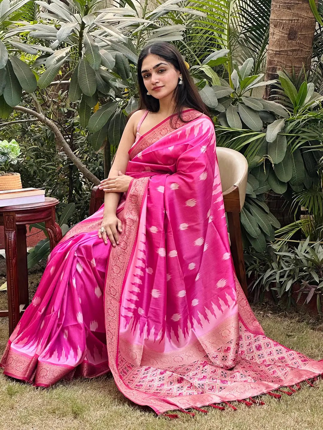 Elegant pink Banarasi saree with zari patola pallu, garden setting