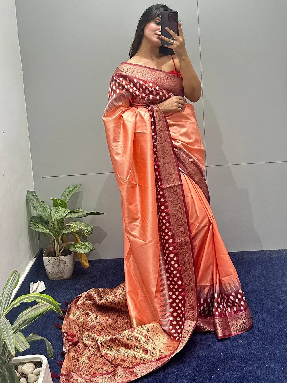 Model wearing peach Banarasi saree with Patola pallu indoors