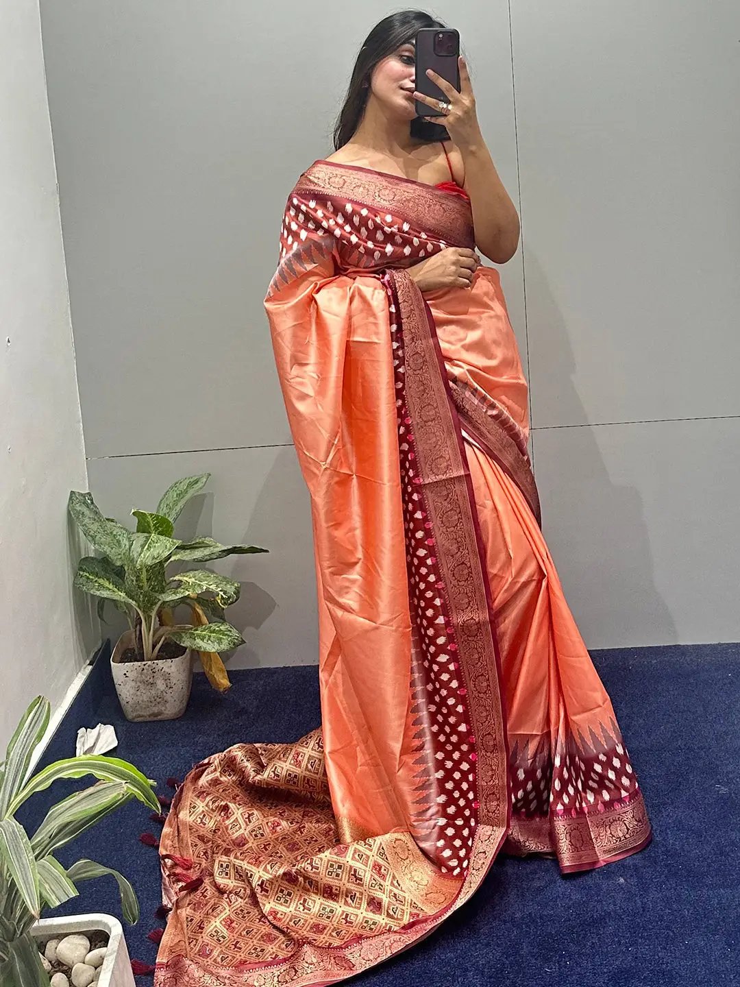 Model wearing peach Banarasi saree with Patola pallu indoors