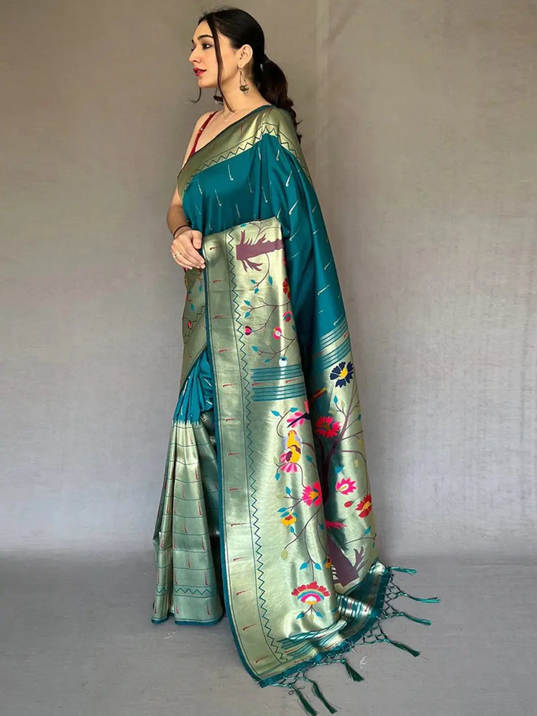 Side view of teal Paithani saree with intricate zari border.