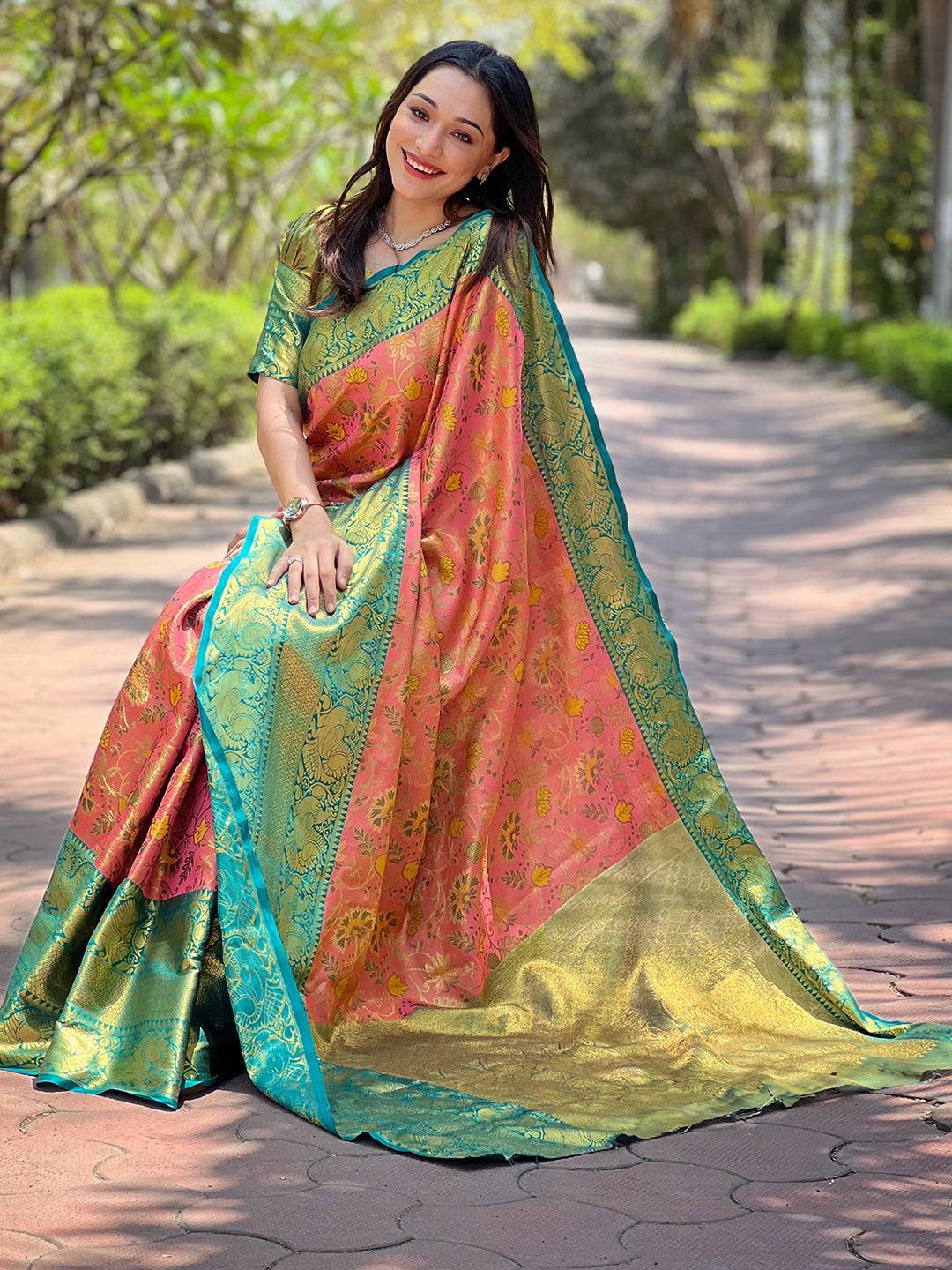 Model sitting in pink Banarasi tissue silk saree