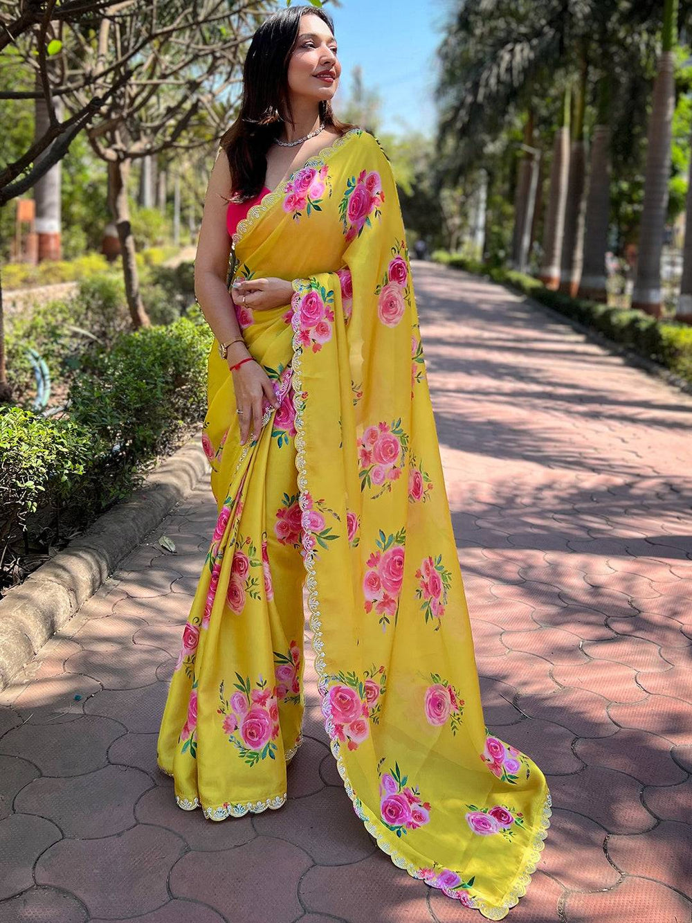 Elegant yellow saree with pink floral design and zircon border