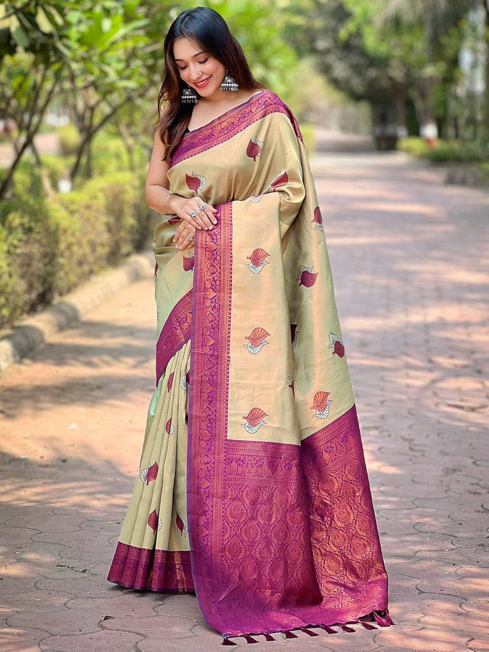 Model wearing light green saree with intricate maroon border