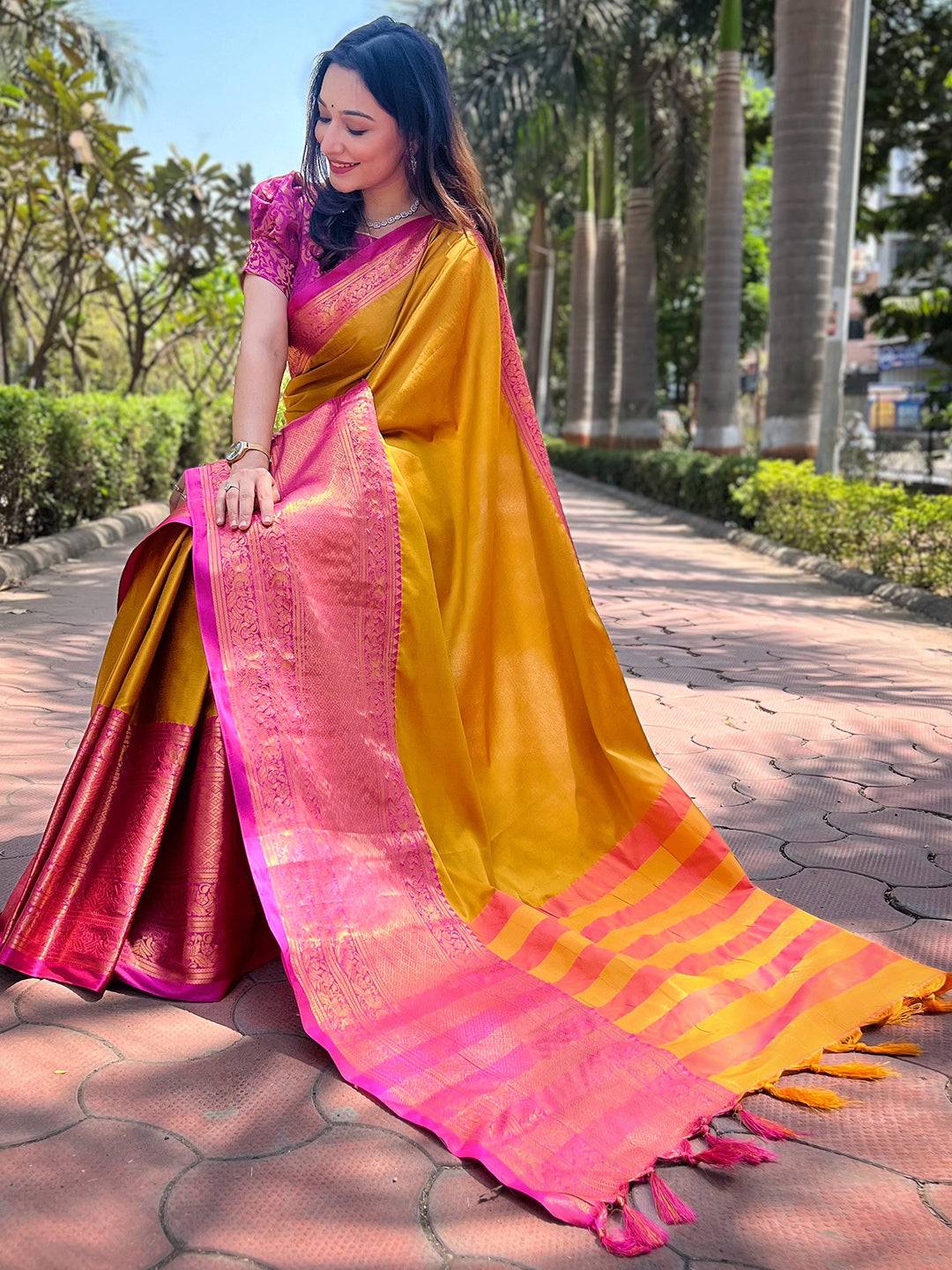 Mustard silk saree with pink Kanjivaram border draped elegantly
