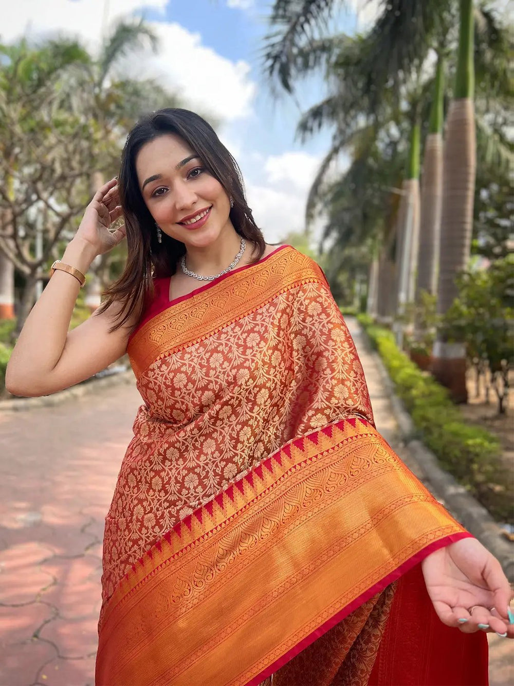 Close-up of orange gold tissue saree with jacquard woven patterns.