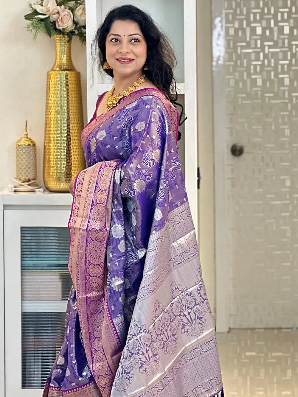 Side view of woman in purple tissue silk saree