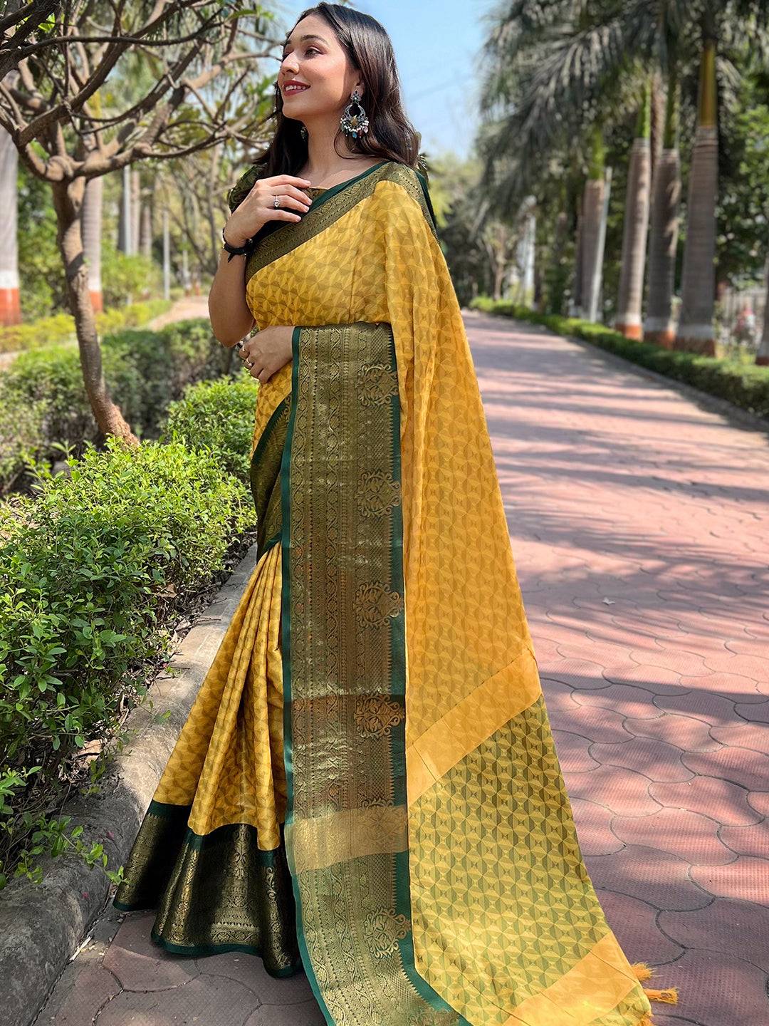 Model showcasing yellow Kanjivaram saree with green accents