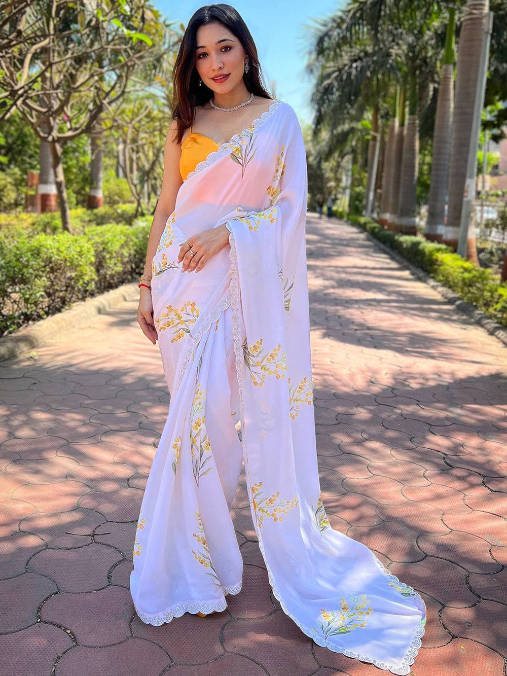 Full view of white floral satin georgette saree with zircon border