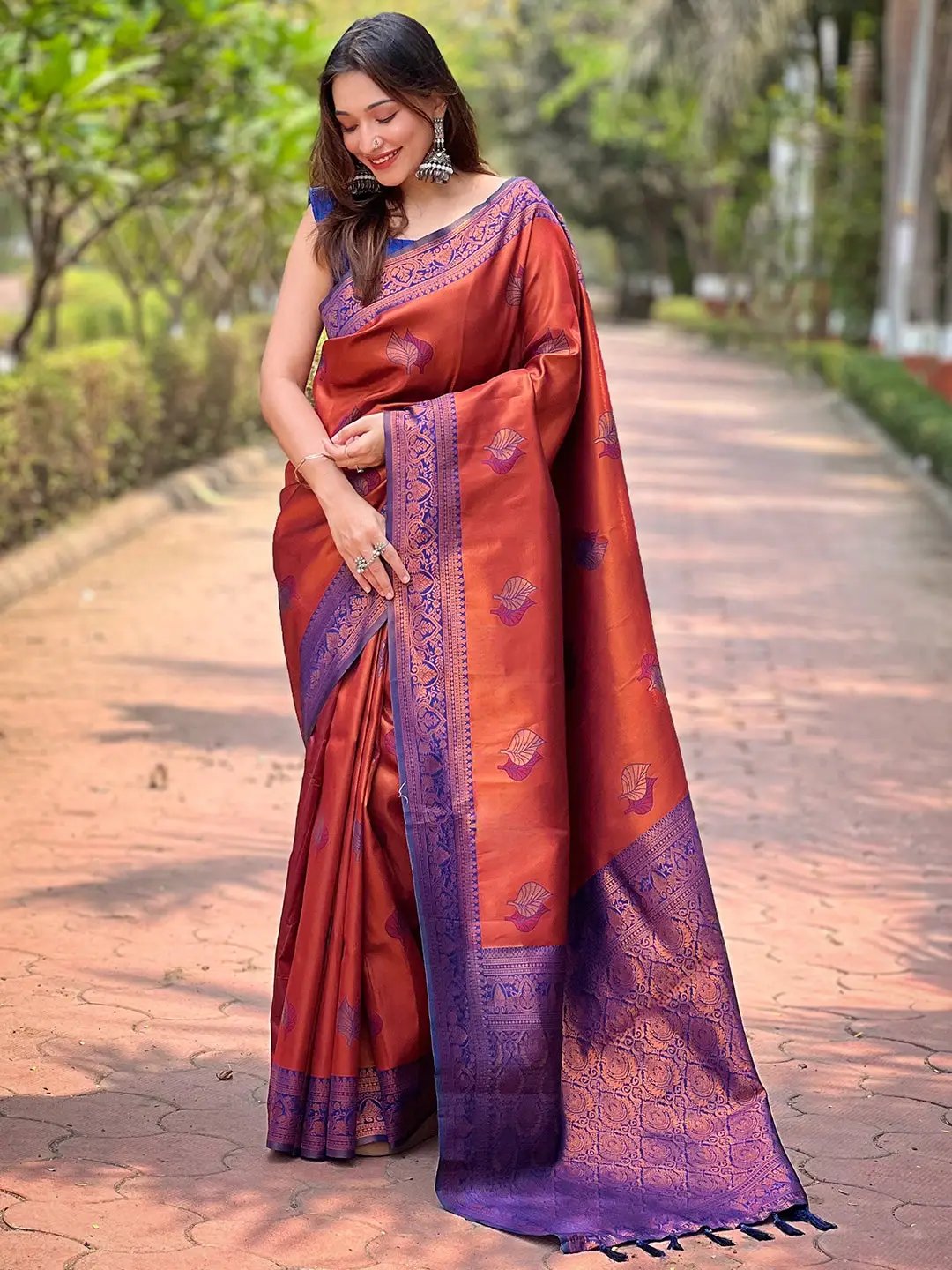 Elegant rust red Kanjivaram saree with intricate gold zari.