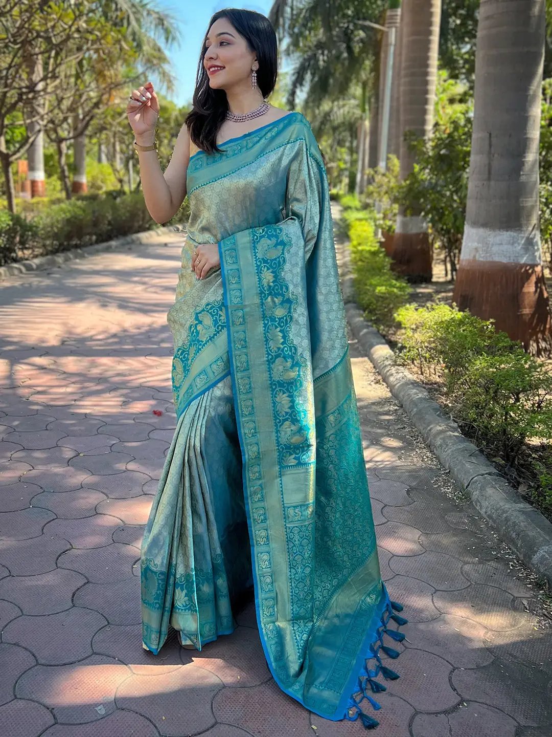 Elegant woman in gold tissue Kanjivaram silk saree outdoors